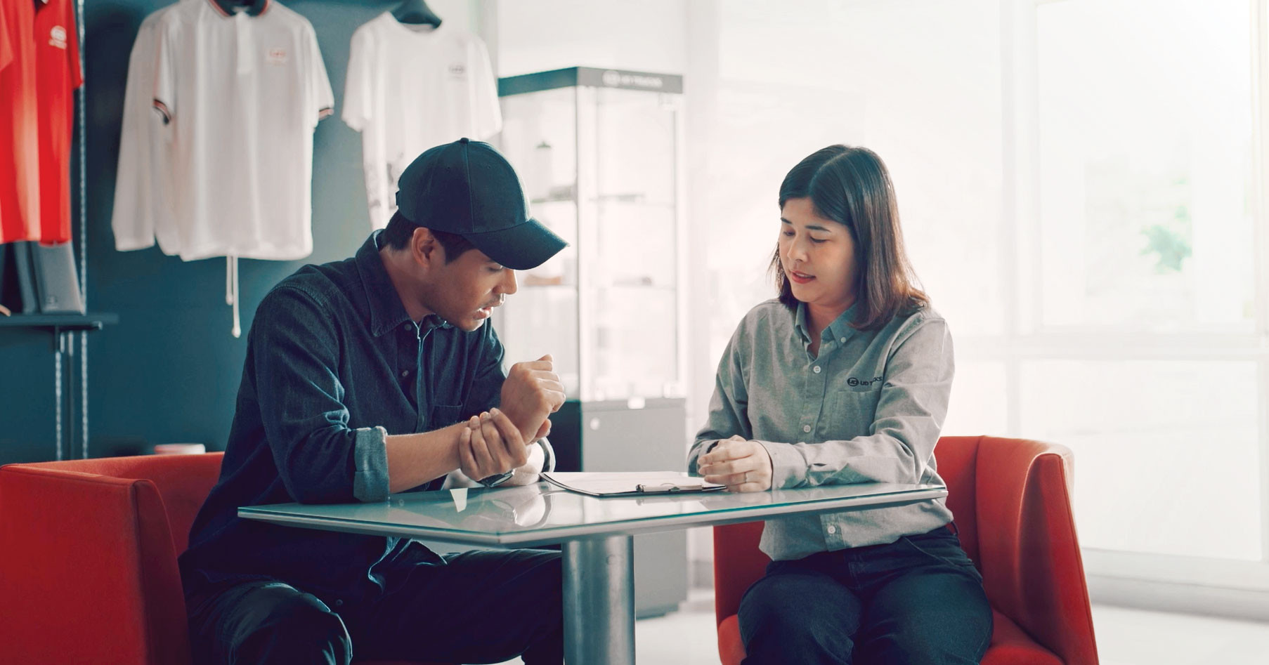 Service contract Two people sitting at a table discussing papers in a modern office setting.