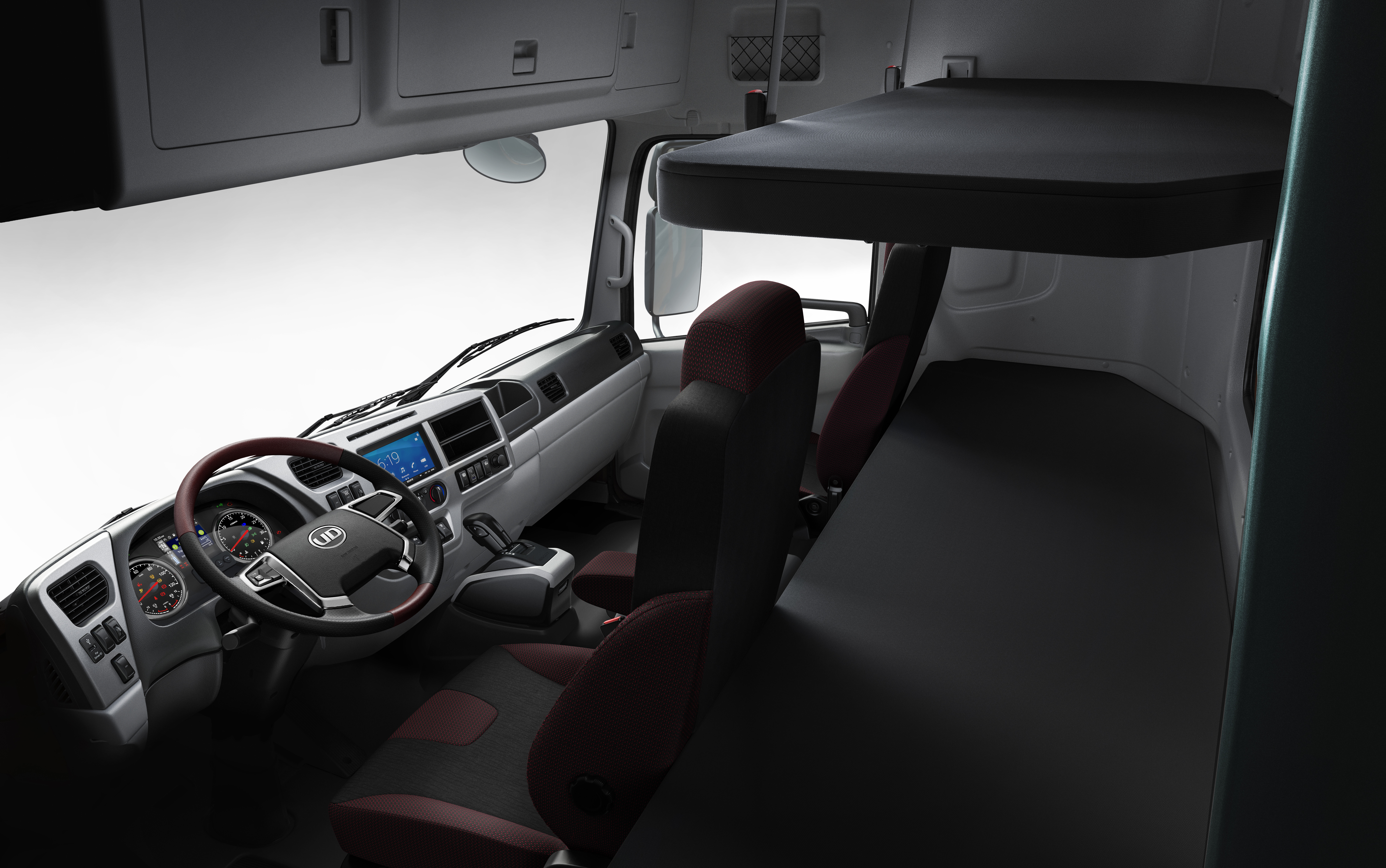 Quester Truck cabin interior with two seats, overhead compartments, and a sleeping bunk.