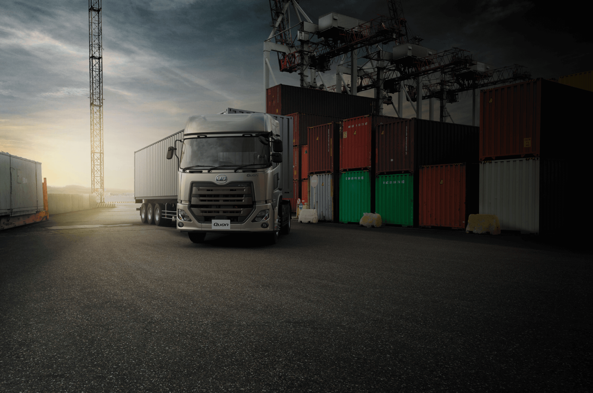 港でコンテナを積んだトラックが夕暮れ時に停車している。
