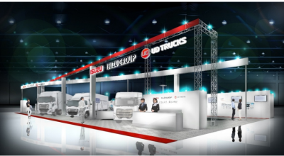 屋内展示会で大型トラック数台が照明の下に並ぶブース