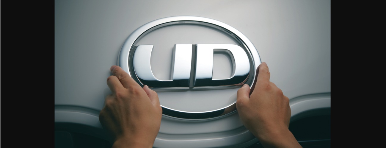 両手でUDトラックスのロゴバッジに触れている様子