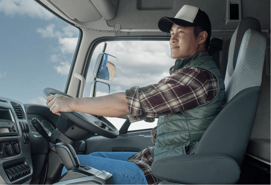 Pria mengenakan topi mengemudi truk di siang hari.